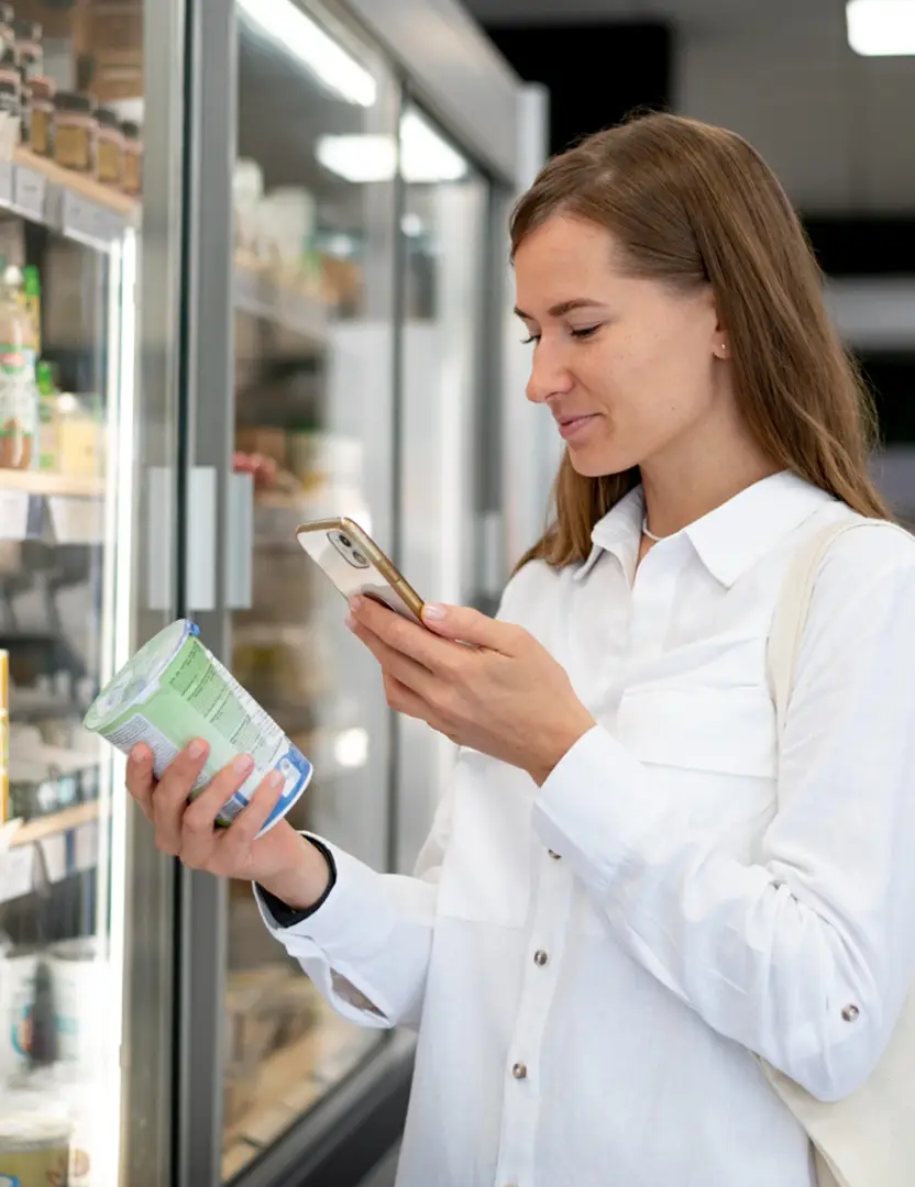 Femme qui scan un produit en faisant ses courses au supermarché